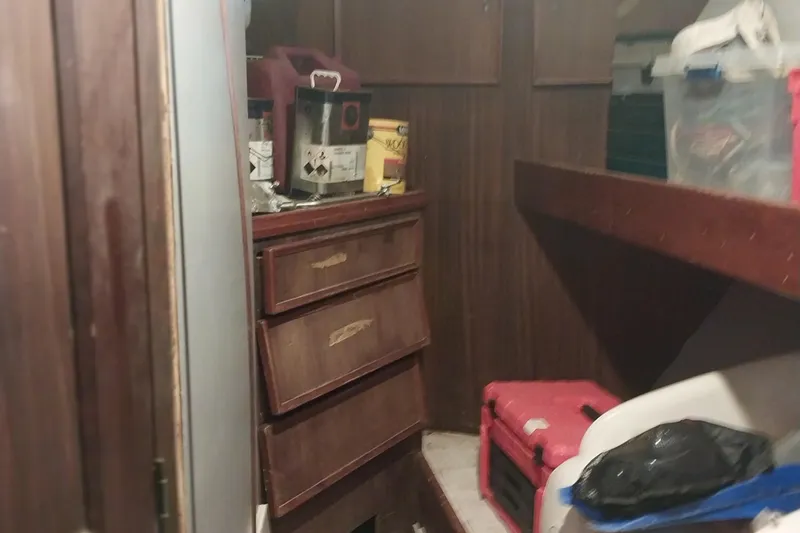 Slide: The Image of Interior of 1982 Hatteras 61 Motor Yacht with wooden cabinets and storage items. - 13