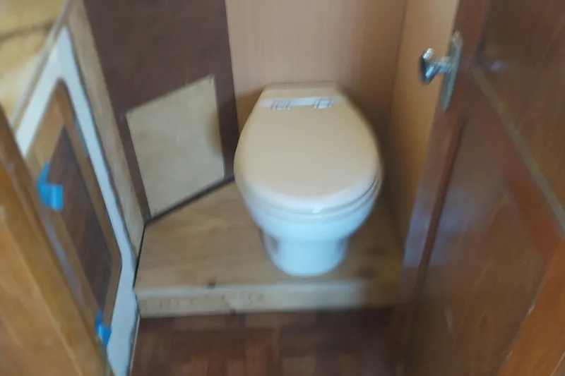 Slide: The Image of 1982 Hatteras 61 Motor Yacht bathroom with wooden interior and compact toilet. - 16