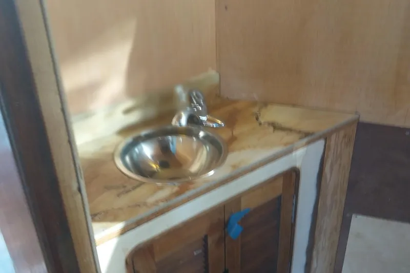 Slide: The Image of 1982 Hatteras 61 Motor Yacht interior with a compact sink and wooden cabinetry. - 17