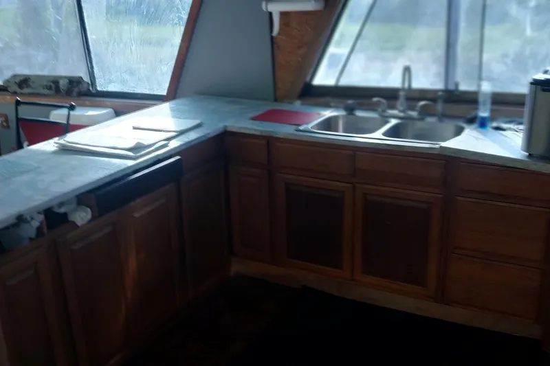 Slide: The Image of 1982 Hatteras 61 Motor Yacht kitchen with wooden cabinets and dual sink. - 18