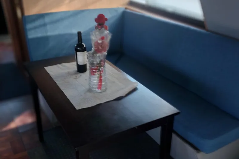 Slide: The Image of Interior of 1982 Hatteras 61 Motor Yacht with table, wine, and flowers. - 20