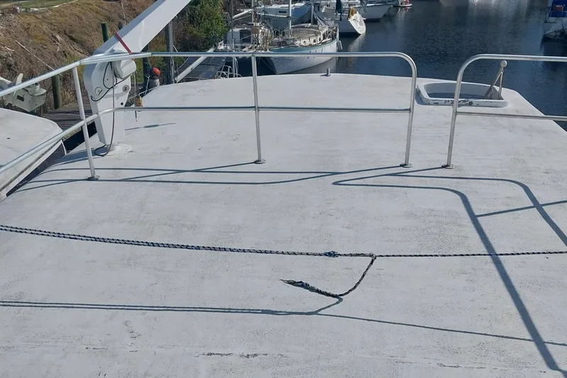 Slide: The Image of 1982 Hatteras 61 Motor Yacht deck with railing, docked near other boats. - 4