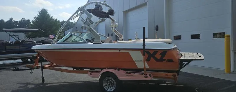 Slide: The Image of 2007 MasterCraft X1 boat on trailer, parked near a building, with wakeboard tower. - 26