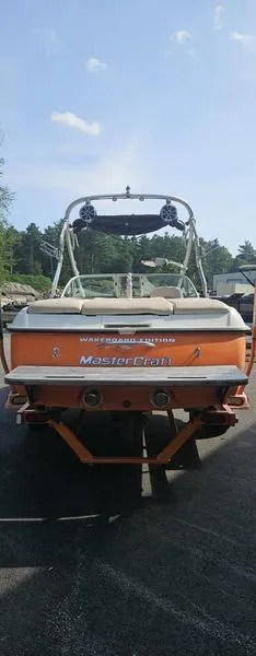 Slide: The Image of 2007 MasterCraft X1 boat, orange and white, rear view with wakeboard tower. - 28