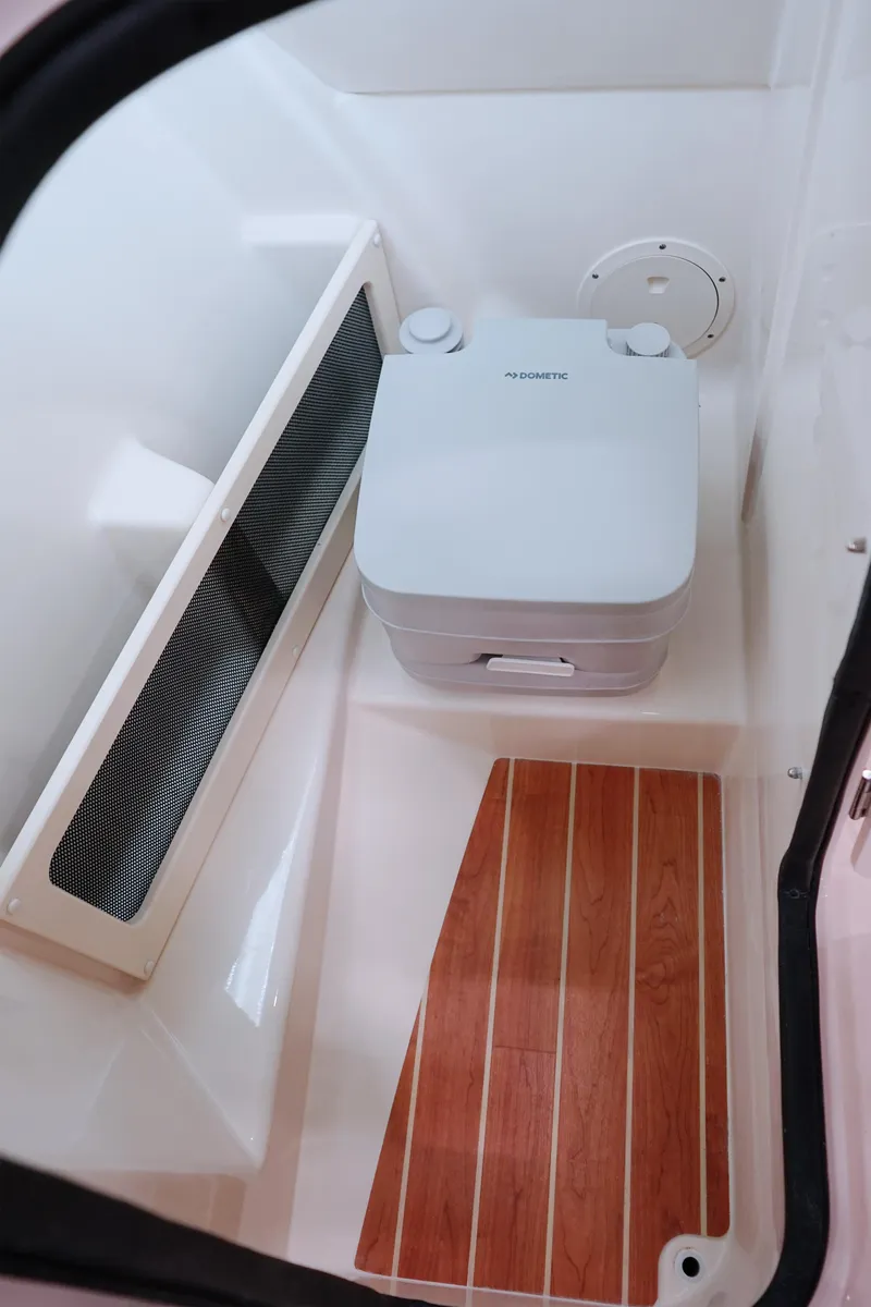 Slide: The Image of 2026 Grady-White 215 Freedom boat interior with portable toilet and wood flooring. - 6