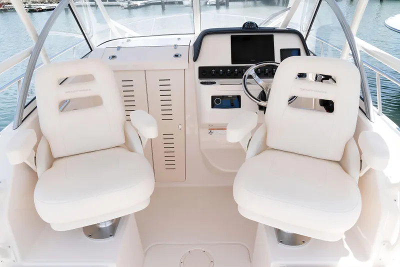 Slide: The Image of 2026 Grady-White 215 Freedom boat interior with dual white captain chairs and control panel. - 7