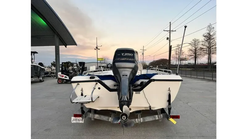Slide: The Image of 2001 Skeeter 2200 ZX boat with outboard motor, parked outdoors at sunset. - 3