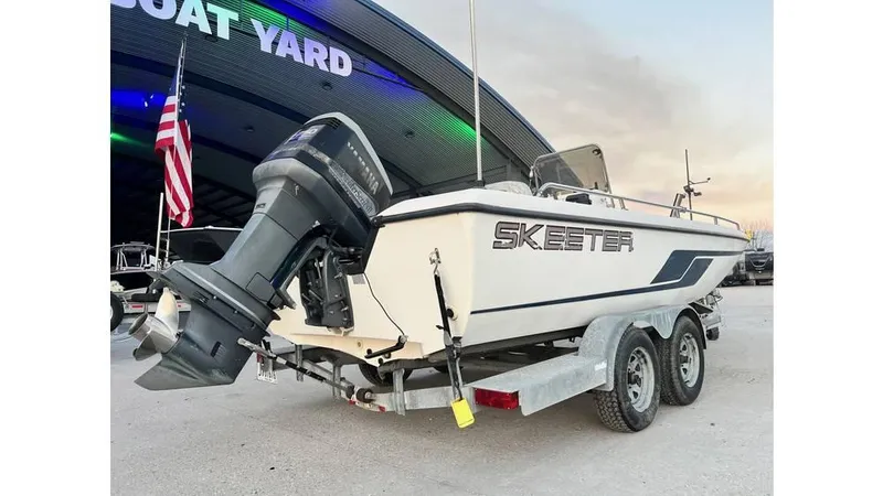 Slide: The Image of 2001 Skeeter 2200 ZX boat on trailer outside dealership with American flag. - 7