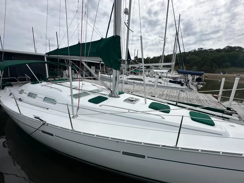 Slide: The Image of 2004 Beneteau 393 sailboat docked at marina under cloudy sky. - 12