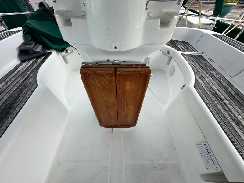 Slide: The Image of Cockpit of 2004 Beneteau 393 sailboat with wooden table and white seating. - 25