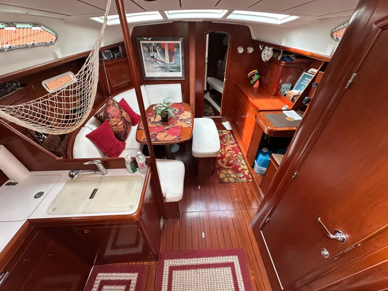 Slide: The Image of Interior of a 2004 Beneteau 393 sailboat with wood finish and cozy seating area. - 31