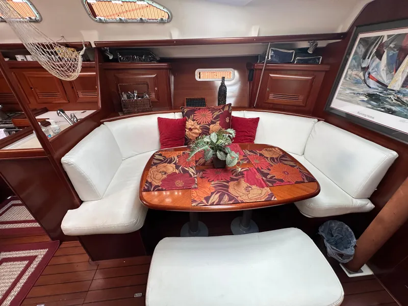 Slide: The Image of Cozy interior of a 2004 Beneteau 393 sailboat with elegant dining area and floral decor. - 36