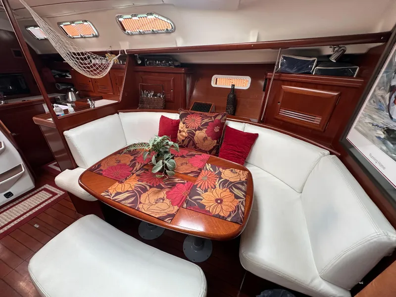 Slide: The Image of Interior of 2004 Beneteau 393 sailboat with cozy dining area and floral decor. - 37