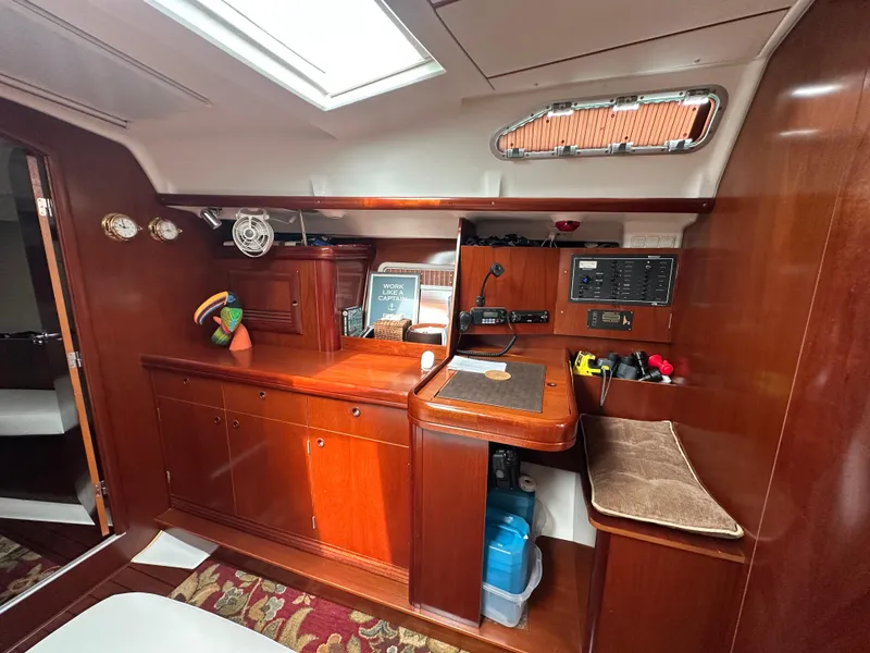 Slide: The Image of Interior of 2004 Beneteau 393 sailboat with wooden cabinetry and navigation station. - 38