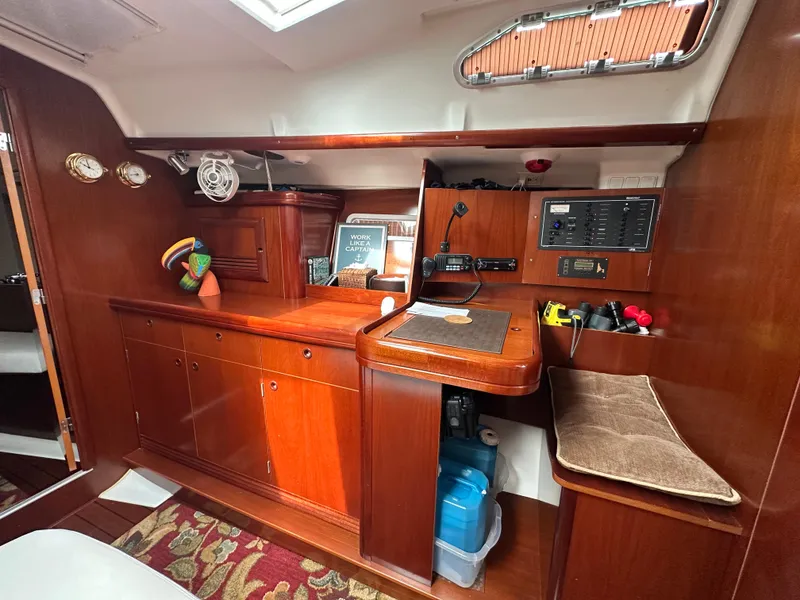 Slide: The Image of Interior of 2004 Beneteau 393 sailboat with wooden cabinetry and navigation station. - 39