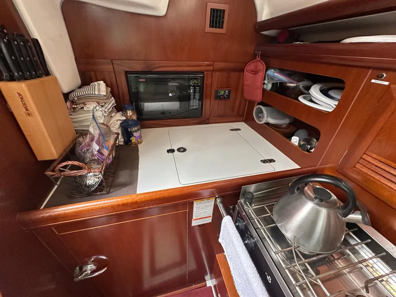 Slide: The Image of Cozy galley kitchen in 2004 Beneteau 393 yacht with microwave and kettle. - 47