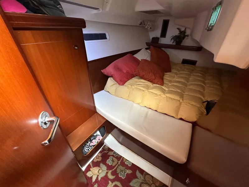 Slide: The Image of Cozy cabin interior of 2004 Beneteau 393 sailboat with bed and wooden furnishings. - 49