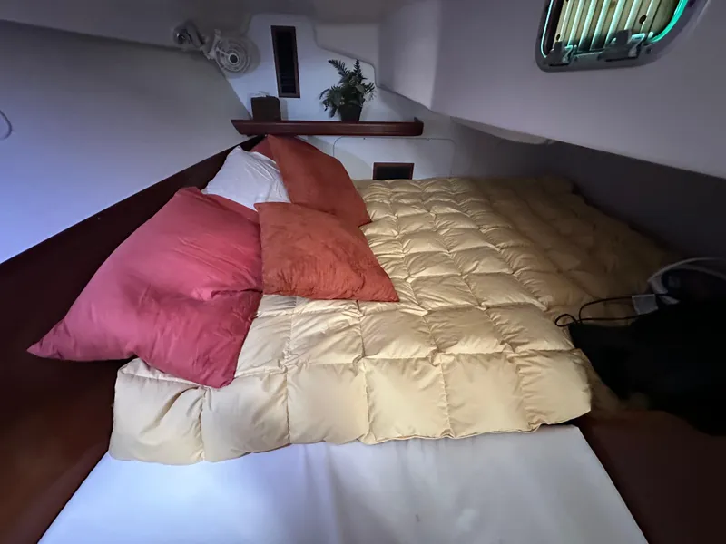 Slide: The Image of Cozy cabin interior of 2004 Beneteau 393 sailboat with plush bedding and porthole. - 50