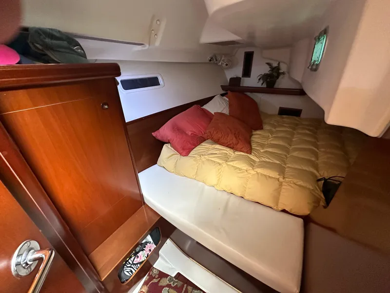 Slide: The Image of Cozy cabin interior of 2004 Beneteau 393 sailboat with bed and wooden cabinetry. - 51