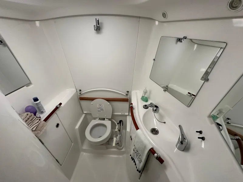 Slide: The Image of Bathroom interior of 2004 Beneteau 393 yacht, featuring toilet, sink, and mirror. - 53