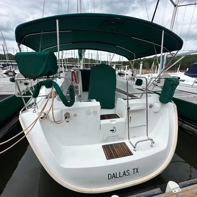 Slide: The Image of 2004 Beneteau 393 sailboat docked, featuring green canopy and covers, located in Dallas, TX marina. - 9
