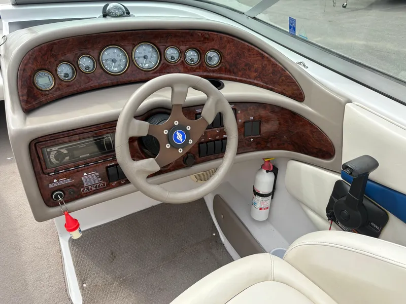 Slide: The Image of 2002 Four Winns 260 Horizon boat dashboard with wood accents and steering wheel. - 10