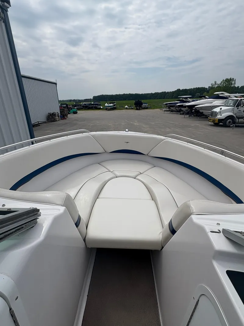 Slide: The Image of 2002 Four Winns 260 Horizon boat with white seating, parked outdoors. - 14
