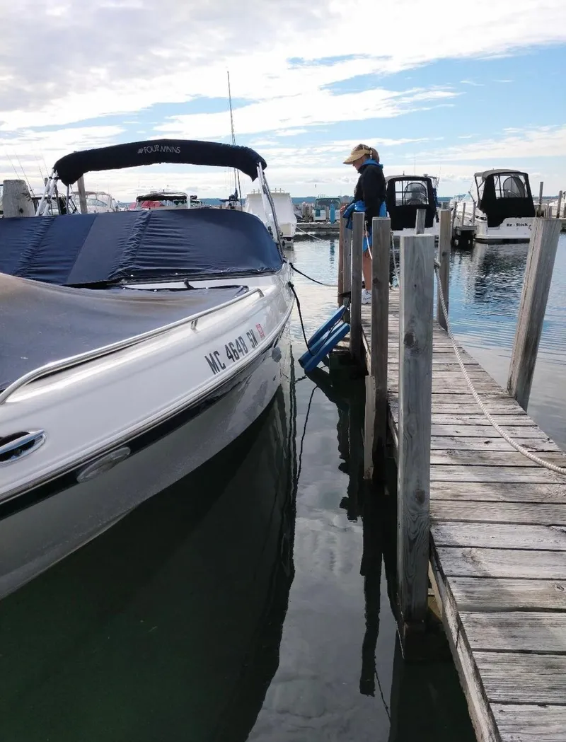 Slide: The Image of 2002 Four Winns 260 Horizon boat docked at a marina with a person nearby. - 4