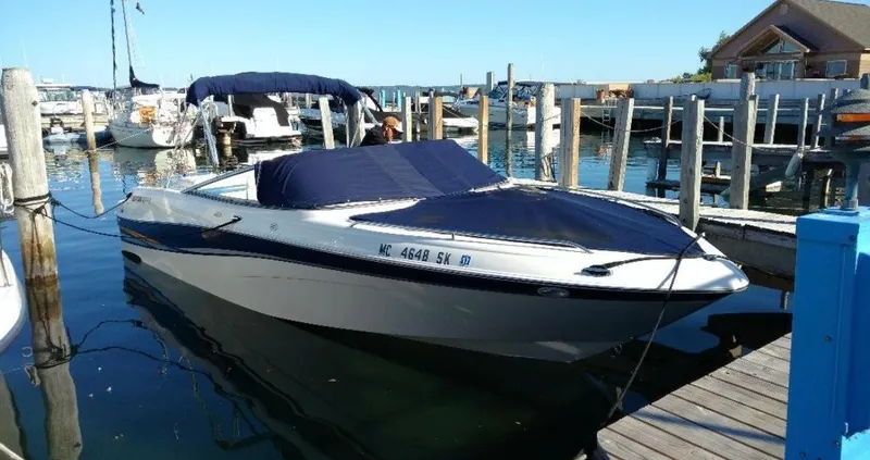 Slide: The Image of 2002 Four Winns 260 Horizon boat docked at a marina with blue cover. - 5