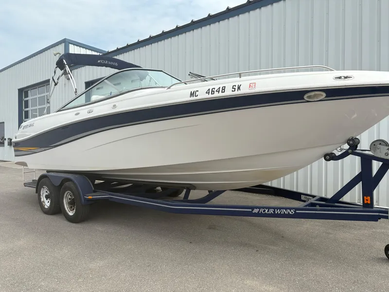 Slide: The Image of 2002 Four Winns 260 Horizon boat on trailer, parked near a building. - 6