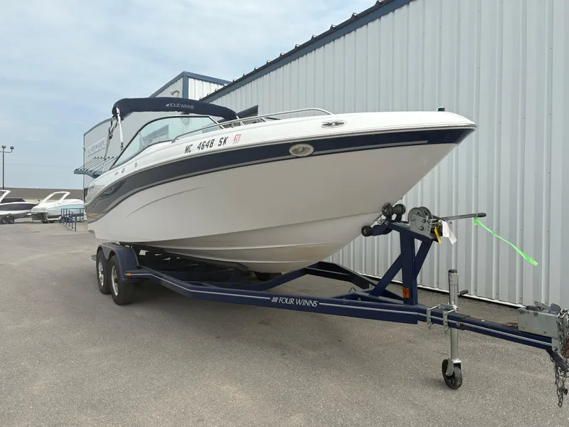 Slide: The Image of 2002 Four Winns 260 Horizon boat on trailer near a metal building. - 7