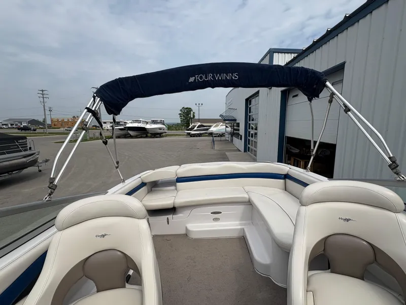 Slide: The Image of 2002 Four Winns 260 Horizon boat with seating and canopy, parked near a marina. - 9