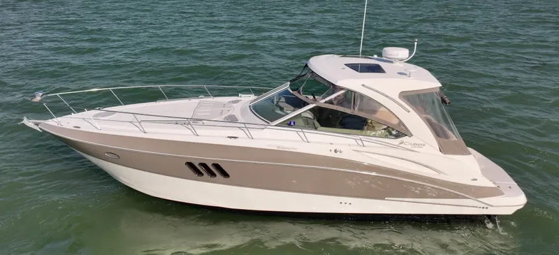 Slide: The Image of 2009 Cruisers Yachts 360 Express on water, side view, sleek design, white and beige exterior. - 11
