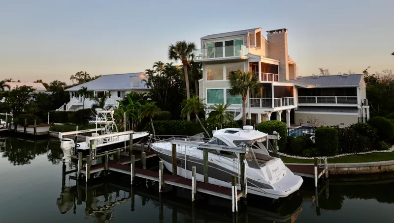 Slide: The Image of 2009 Cruisers Yachts 360 Express docked by waterfront homes at sunset. - 18
