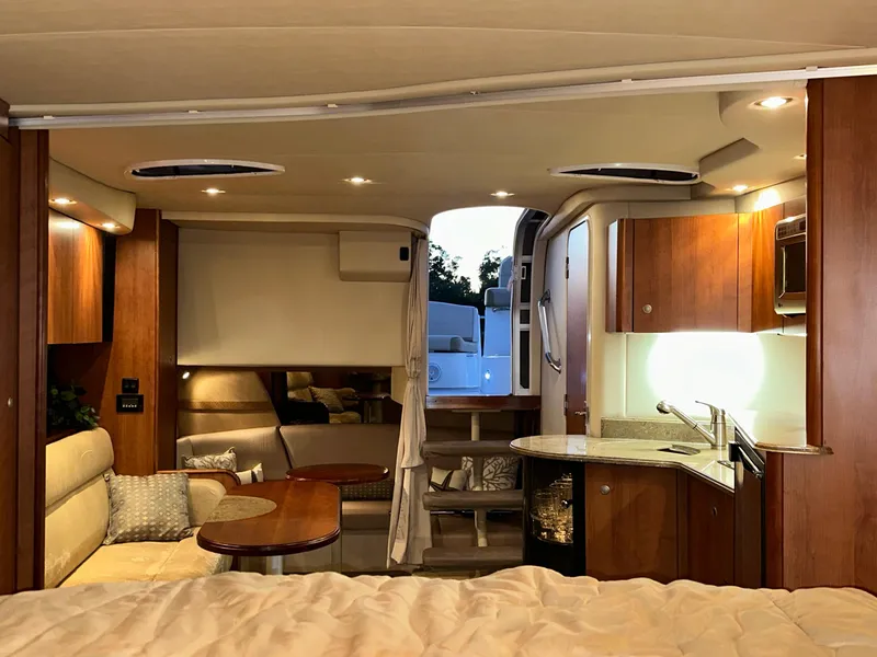 Slide: The Image of 2009 Cruisers Yachts 360 Express interior with cozy seating, kitchenette, and elegant wood finishes. - 44