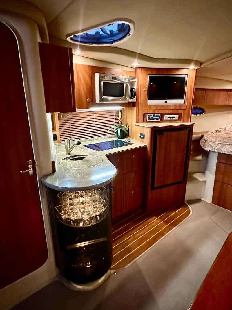 Slide: The Image of 2009 Cruisers Yachts 360 Express interior with kitchen, microwave, and cozy seating area. - 48