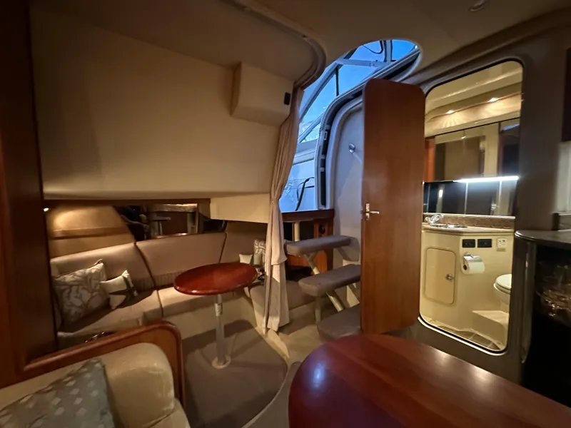 Slide: The Image of 2009 Cruisers Yachts 360 Express interior with cozy seating, table, and kitchenette. - 49