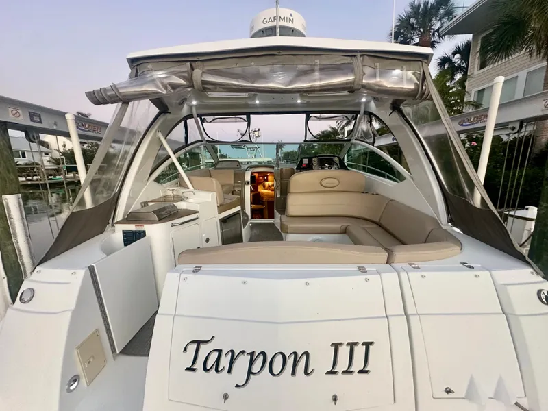 Slide: The Image of 2009 Cruisers Yachts 360 Express, rear view, named "Tarpon III," docked with seating area visible. - 23