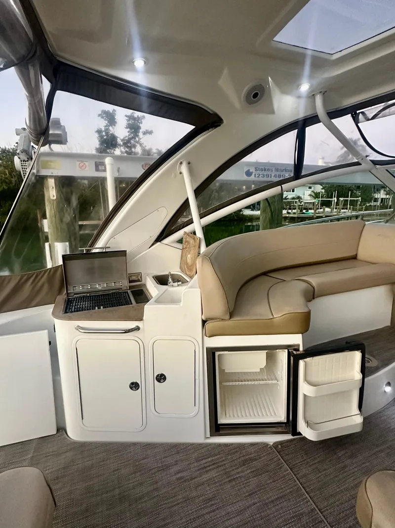 Slide: The Image of 2009 Cruisers Yachts 360 Express interior with seating, mini fridge, and laptop. - 31