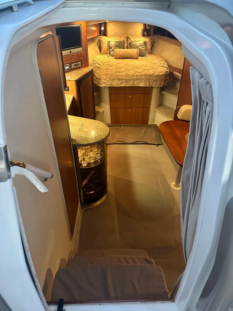 Slide: The Image of 2009 Cruisers Yachts 360 Express cabin interior with bed, seating, and wooden cabinetry. - 36