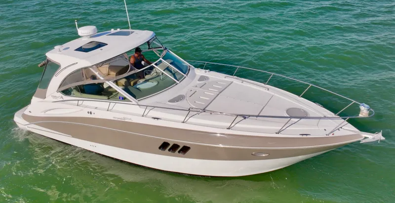 Slide: The Image of 2009 Cruisers Yachts 360 Express on open water, sleek design, white and beige exterior. - 6