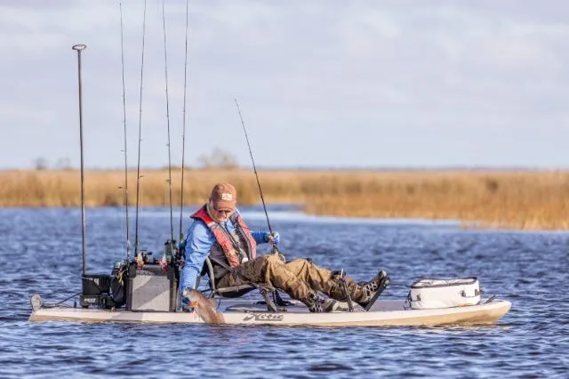 Slide: The Image of Person fishing on a 2025 Hobie LYNX kayak in a serene lake setting. - 4