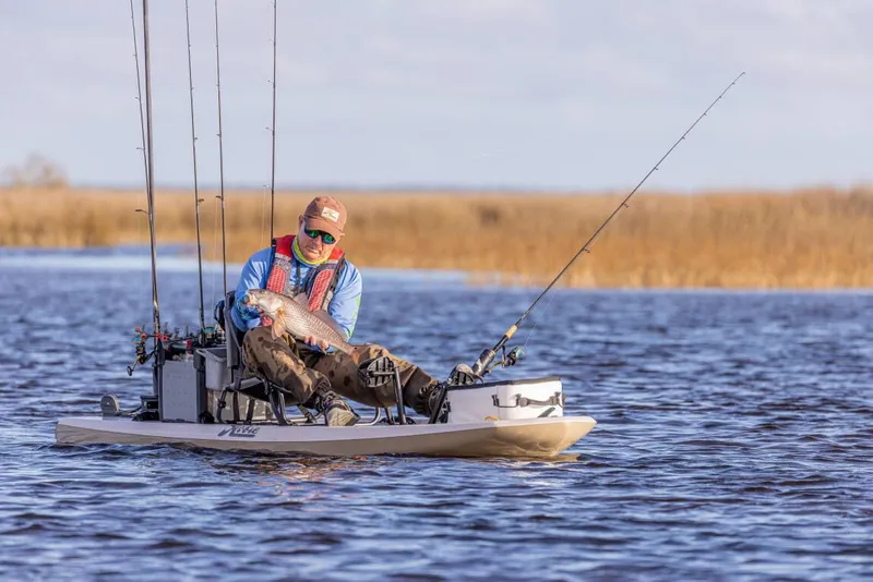 Slide: The Image of Man fishing on a 2025 Hobie LYNX kayak in a serene lake setting. - 5