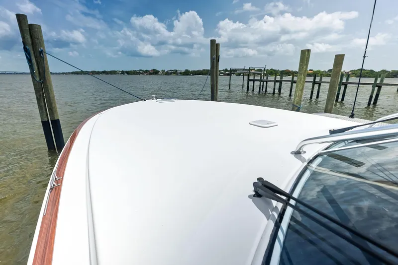 Slide: The Image of 2010 Viking 52 Open yacht docked by wooden posts under a partly cloudy sky. - 37