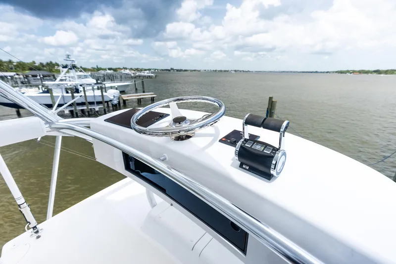 Slide: The Image of Helm of 2010 Viking 52 Open yacht with steering wheel and controls, overlooking marina. - 44