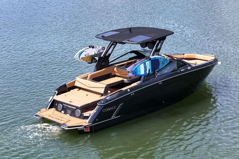 The Image of 2026 Cobalt R8 Surf boat on water, featuring sleek design and surfboards. - 0