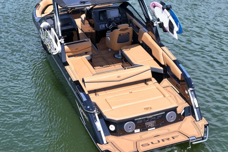 Slide: The Image of 2026 Cobalt R8 Surf boat with tan interior on water, featuring surfboards. - 10