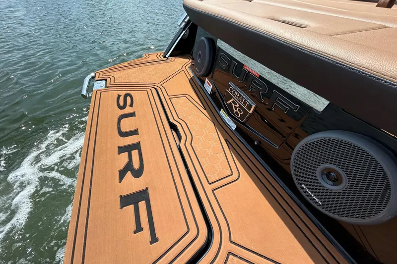 Slide: The Image of 2026 Cobalt R8 Surf boat with custom deck and audio system on water. - 13