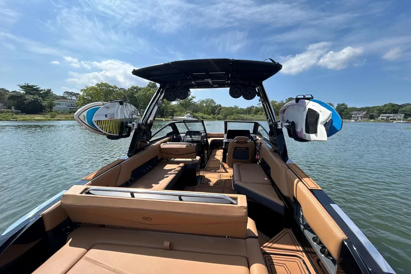 Slide: The Image of 2026 Cobalt R8 Surf boat interior with surfboards, on a sunny lake. - 18