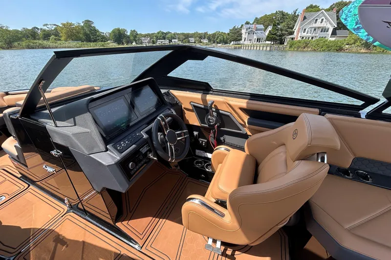 Slide: The Image of 2026 Cobalt R8 Surf boat interior with modern dashboard and luxurious tan seating. - 30